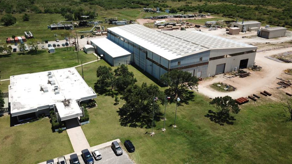 Aerial view of an industrial building with a large parking lot