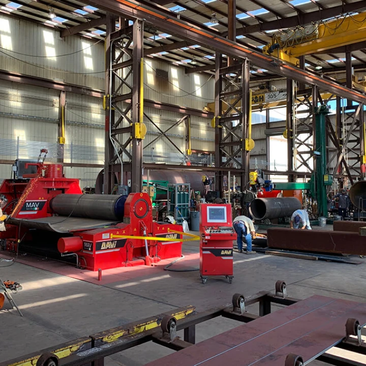 Industrial workshop with large machinery and workers.